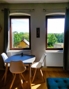 ワイマールにあるNostalgie Apartment Weimarの窓2つ付きの客室で、テーブルと椅子が備わります。