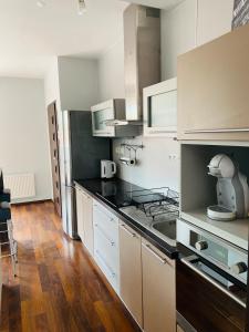 魯容貝羅克的住宿－Apartment Mira，厨房配有白色橱柜和黑色台面