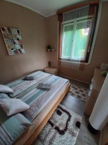 Un dormitorio con una cama grande y una ventana en Pálma Vendégház, en Zalakaros