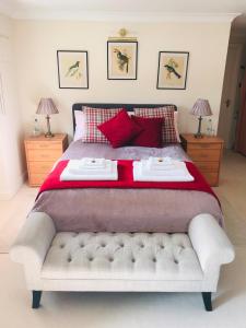 a bedroom with a large bed with red pillows at Charming Hen Cottage Countryside Retreat Lincoln in Lincoln