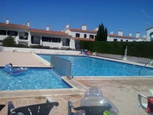 a large swimming pool with a child in the water at Apartamento Siesta Mar 1 Apartamento 26 Cala en Porter in Cala'n Porter