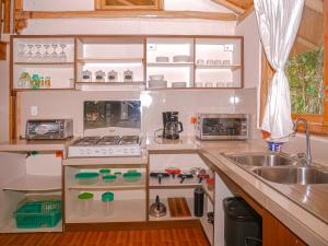 a small kitchen with a sink and a stove at La Casa en el Aire Mindo, 4 Dormitorios in Mindo +34 photos