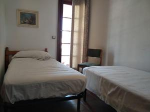 two beds in a room with a window at Apartamento Siesta Mar 1 Apartamento 26 Cala en Porter in Cala en Porter