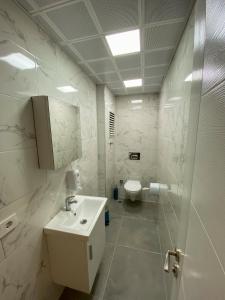 a white bathroom with a sink and a toilet at İpek Apart in Antalya