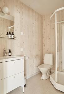 y baño blanco con aseo y ducha. en Hotelli Vihannonkulma, en Loimaa