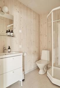 a white bathroom with a toilet and a shower at Hotelli Vihannonkulma in Loimaa +60 photos