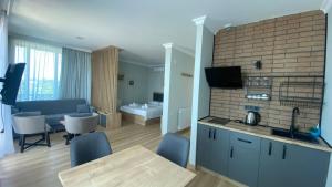 a kitchen and living room with a table and a couch at Green Hills Batumi in Batumi