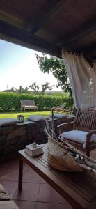 a porch with a bench and a table with a book at Sardinia82 Sunsetplace in Palau