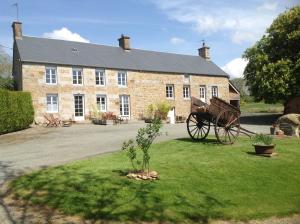 an old brick building with a horse drawn carriage at LES ROCAILLES in La Forêt-Auvray