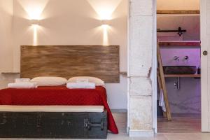 1 dormitorio con 1 cama con cabecero de madera en Pasithèa Suite, en Ceglie Messapica