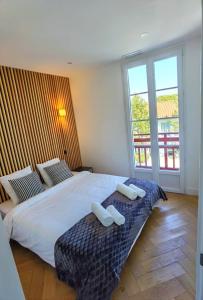 a bedroom with a large bed with two towels on it at Piscine et jacuzzi Loft ravissant dans une maison basque in Anglet