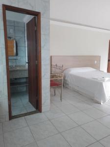 a bedroom with a bed and a mirror and a chair at Hotel Recanto da Itália in Nova Friburgo +37 photos