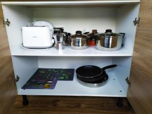 a shelf with some pots and pans on it at Lidda Apartment in residential area in Varna City