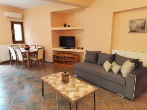 a living room with a couch and a table at Christie's ground floor apartment by the sea in Kato Gatzea