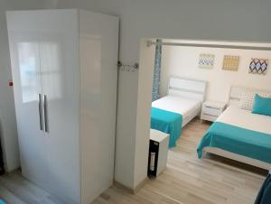 a bedroom with two beds and a sliding glass door at Daffne Otel in Canakkale