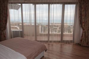 a bedroom with a bed and a large window at Millennium Apart Complex in Sveti Vlas +73 photos