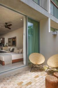 - une chambre avec un lit, deux chaises et une fenêtre dans l'établissement Studio wterrace, hammock, and pool access, à Tulum