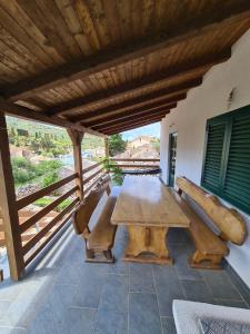 una mesa de madera y sillas en un patio en Kuća za odmor Buba, en Murter