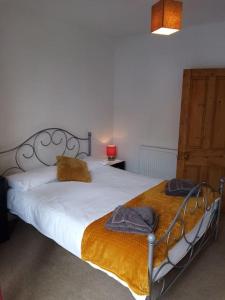 a bedroom with a bed with two towels on it at Bridge View Victorian Townhouse Central Aberystwyth Sleeps 6 in Aberystwyth
