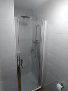 baño con cabina de ducha con puerta de cristal en Céntrico Estudio, en Sada