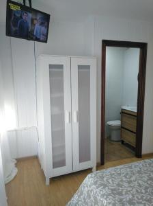 1 dormitorio con armario blanco y aseo en Céntrico Estudio, en Sada