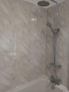 a shower in a bathroom with a beige tile wall at Bridge View Victorian Townhouse Central Aberystwyth Sleeps 6 in Aberystwyth +27 photos