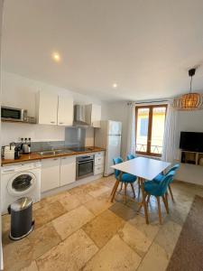 a kitchen with a table and chairs in it at MARIUS - Hyper centre - 2 chambres - Wifi in Cassis +13 photos