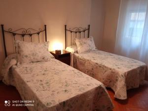 two beds sitting next to each other in a bedroom at Guimar in Avilés