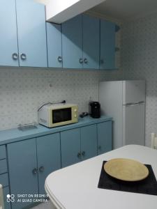 a kitchen with a table with a microwave and a refrigerator at Guimar in Avilés