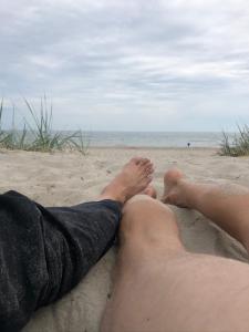 Hotell Persnäs في Persnäs: شخصان يستلقون على الرمال على الشاطئ