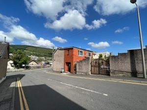 una calle vacía con una casa y una valla en The Duffryn, en Mountain Ash