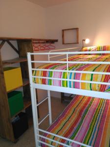 1 dormitorio con 2 literas y una manta colorida en Apto para Vacaciones con WIFI, en Chipiona