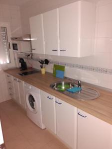 a kitchen with a sink and a washing machine at Apto para Vacaciones con WIFI in Chipiona