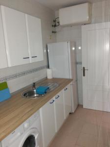 a kitchen with a sink and a washing machine at Apto para Vacaciones con WIFI in Chipiona