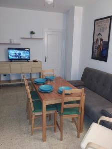 sala de estar con mesa de madera y sofá en Apto para Vacaciones con WIFI, en Chipiona