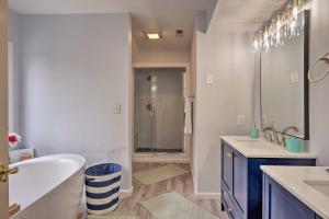 ein weißes Badezimmer mit Badewanne und Waschbecken in der Unterkunft Riverfront Retreat in Urbanna with Indoor Hot Tub! in West Irvington + 37 Fotos