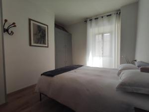 Un dormitorio con una gran cama blanca y una ventana en Gnazzano Home 1, en Loiano