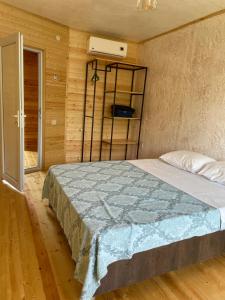 um quarto com uma cama num quarto com paredes de madeira em Cottage Gageta em Ureki