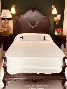 - un grand lit avec une tête de lit en bois dans une chambre dans l'établissement Quinta D`Manuel Maria- Rural Charm Houses, à Amarante