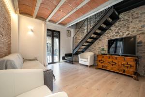 sala de estar con TV y pared de ladrillo en Hauzify I Apartaments Montblanc, en Montblanc