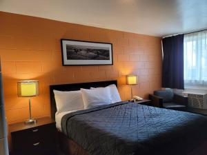 a hotel room with a bed and two lamps at Roadking Inns Motel in Calgary