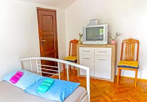 a bedroom with a bed and a tv and two chairs at Private rooms - Tivat in Tivat