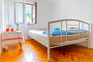a white bed in a room with a wooden floor at Private rooms - Tivat in Tivat