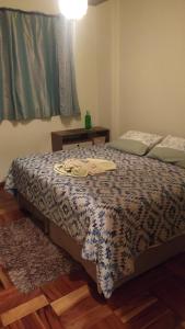 a bedroom with a bed with a comforter on it at Recantto do Divino B&B in Campos do Jordão