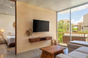 a living room with a flat screen tv on a wall at New Tulum Luxury 2BRBath with Private Pool Heart of La Veleta in Tulum