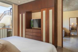 a bedroom with a bed and a tv on a wall at New Tulum Luxury 2BRBath with Private Pool Heart of La Veleta in Tulum +19 photos