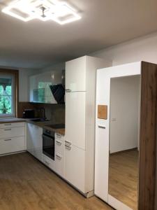 a kitchen with white cabinets and an open door at Bauernhof Podorn in Sankt Kanzian