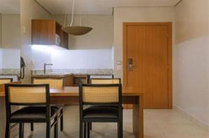 cocina con mesa de madera, sillas y puerta en Salinas Premium Resort en Salinópolis