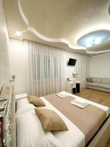 una grande camera da letto bianca con un grande letto e un divano di Affittacamere ELVI 2 a La Spezia