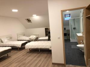 Habitación con 3 camas y espejo. en MAISON MEDIEVALE, en Sarrancolin